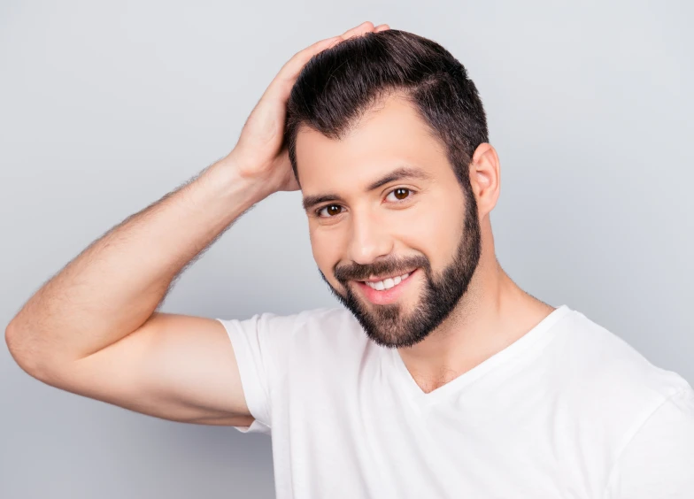 Smiling man touching his hair