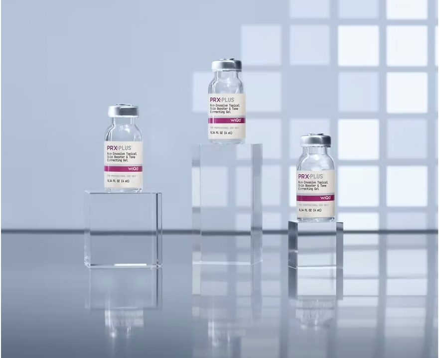 Three vaccine vials displayed on clear stands with a soft blue background.