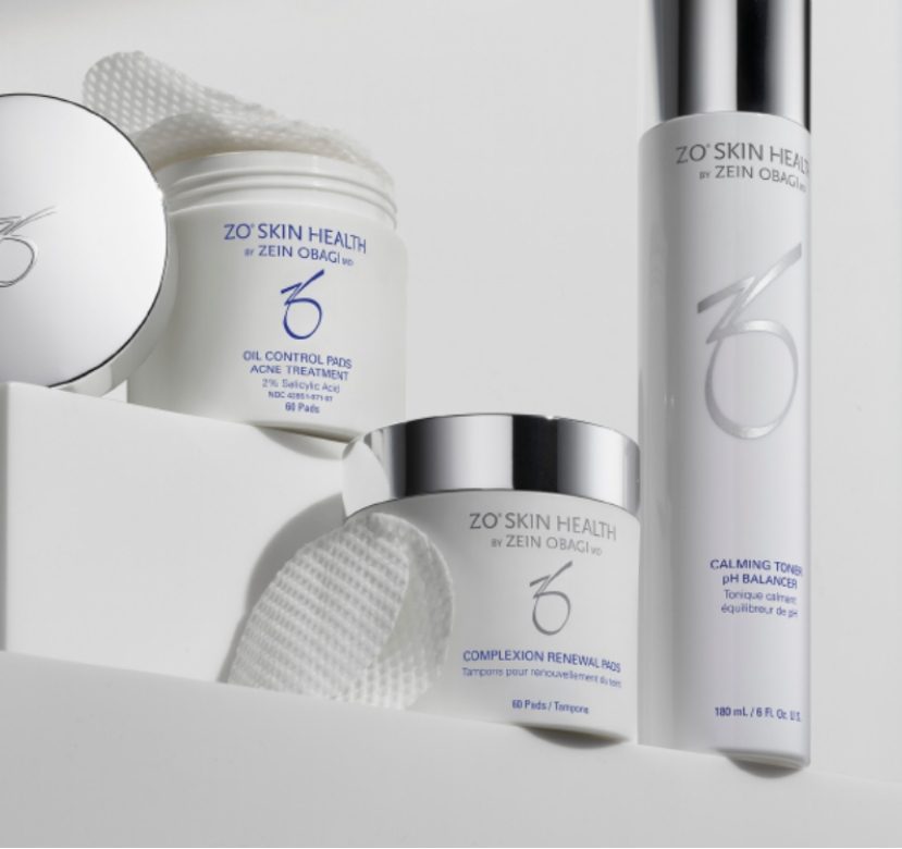 Skincare products set with jars and a bottle on white blocks.