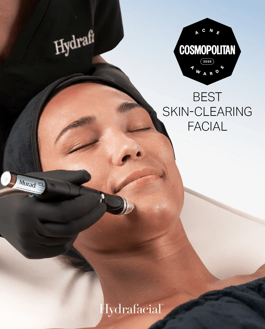 Woman receiving a skin-clearing facial treatment with a Hydrafacial device.