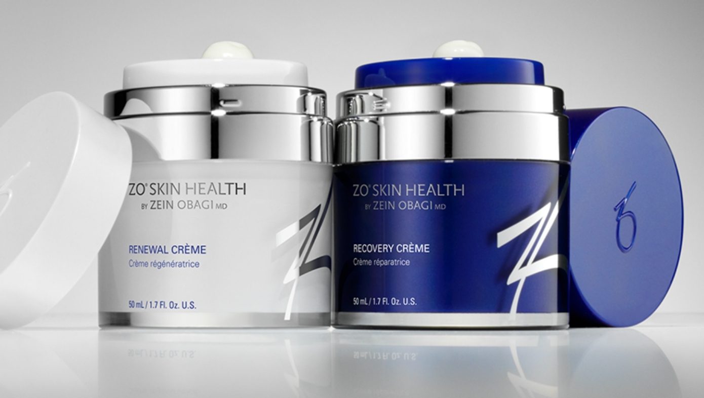 Two skincare cream jars, one white and one blue, with silver lids.